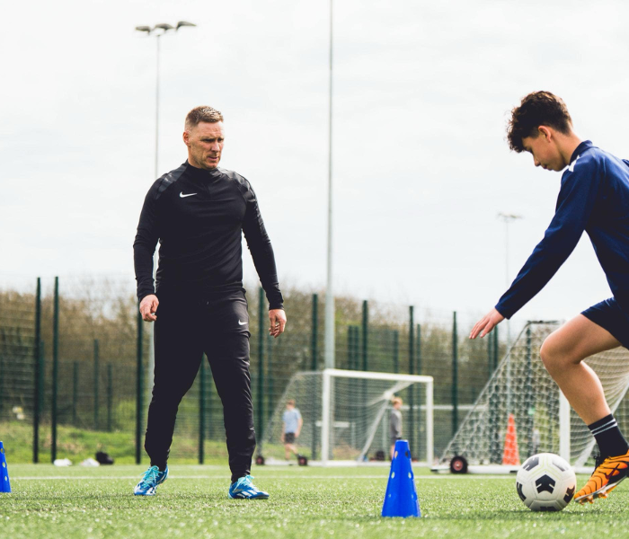 Technical Mastery - Coach observing player practicing ball control skills